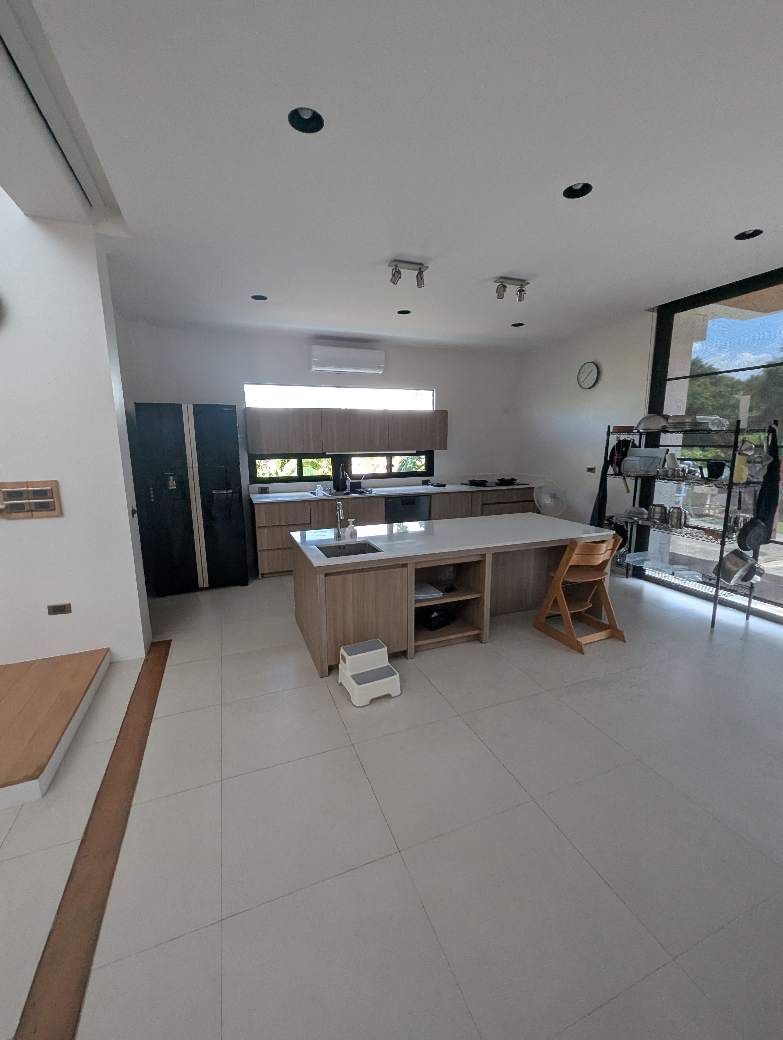Open kitchen with a clear white island and wooden cabinets